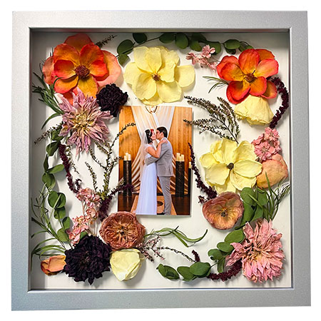 pressed flowers in circle around photo of bride and groom